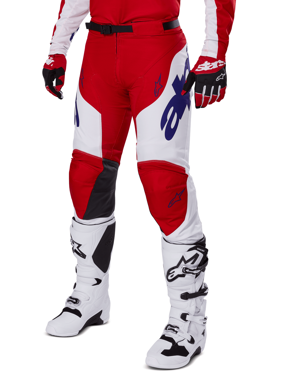 Alpinestars 2025 Racer Veil byxor, motocrossbyxor, röda och vita med blå Alpinestars-logotyper och svarta läderpaneler på knänas insida, bärs med matchande röda handskar och vita motocross-stövlar, matchande utrustningsset för terrängkörning
