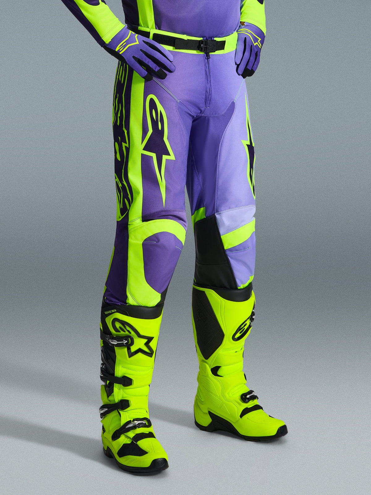 Alpinestars 2026 Racer Portl Pants, Motocross Pants in Purple and Yellow Fluo, worn by a rider with matching fluo yellow boots and purple gloves, featuring bold Alpinestars branding and ergonomic design for off-road performance