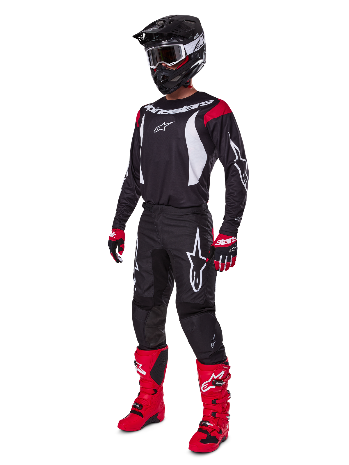 Motocrossförare i komplett Alpinestars 2025 Fluid Haul-utrustningsset, svart tröja med röda och vita detaljer, svarta byxor med vita logotyper, klarröda stövlar, röda och svarta handskar, svart hjälm med goggles, matchande off-road-prestandautrustning