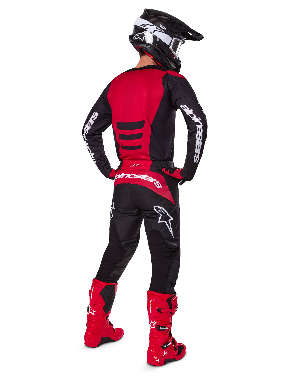Motocrossförare som bär Alpinestars 2025 Fluid Haul-utrustningsset sedd bakifrån, röd och svart tröja med vit logotyp, matchande svarta byxor med röda detaljer, klarröda stövlar och svart hjälm med vita goggles, komplett koordinerad outfit för terrängkörning