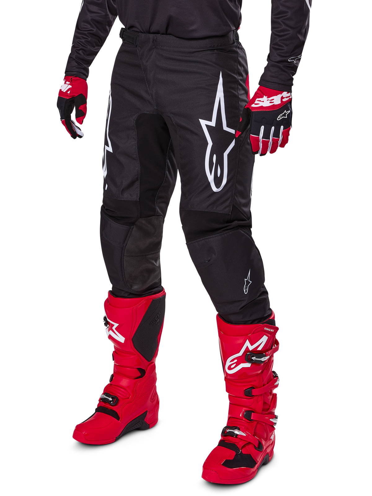 Alpinestars 2025 Fluid Haul byxor, motocrossbyxor, svarta med en stor vit Alpinestars-logotyp, bärs med klarröda stövlar och rödsvarta handskar, slitstark 600D polytygskonstruktion med ergonomisk skärning för terrängkörning