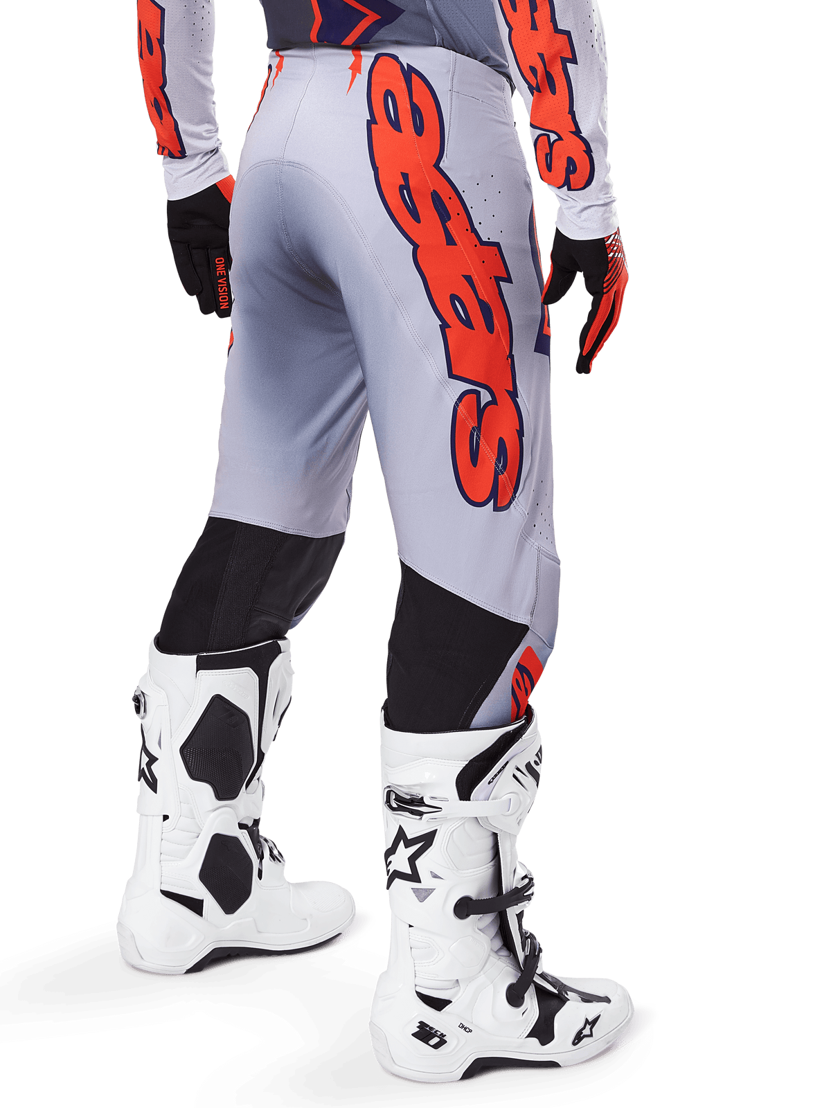 Alpinestars 2025 Supertech Lipan byxor, motocrossbyxor, grå och orange fluo, bärs med matchande tröja och vita stövlar, sett bakifrån med stor orange Alpinestars-grafik, svarta stretchpaneler, professionell racingutrustning för motocross