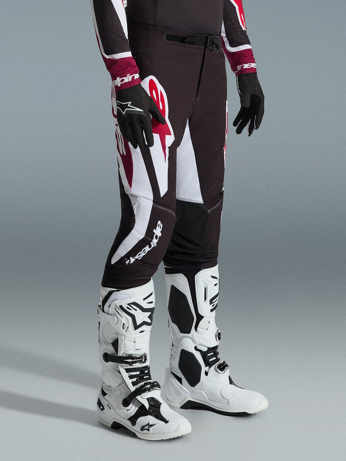 Alpinestars 2026 Supertech AFD Vista Pants, Motocross Pants, Black Red and White, worn with white and black motocross boots and black gloves, featuring large white and red graphic patterns, athletic race fit design