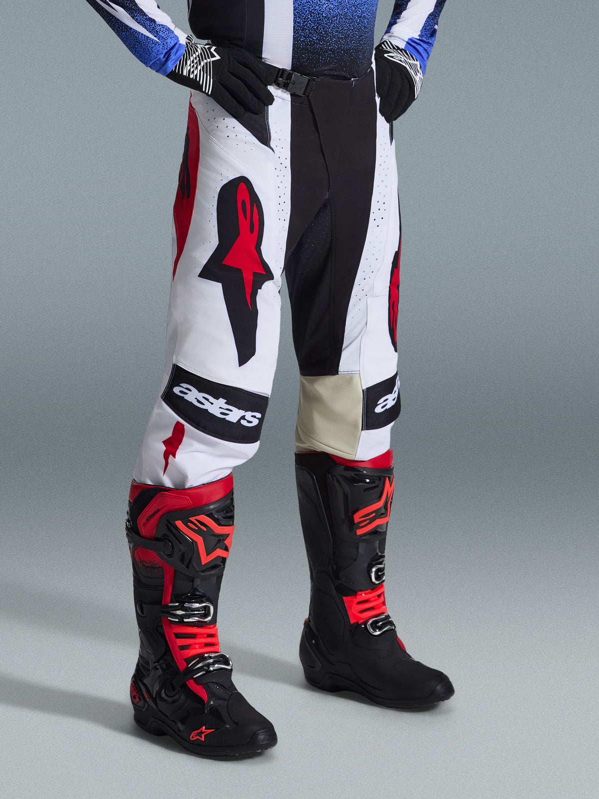 Alpinestars 2026 Techstar Knif Gear Set, Motocross Pants and Boots, White Black and Red, featuring bold branding and multi-material construction, worn with black gloves, professional racing kit for off-road performance.