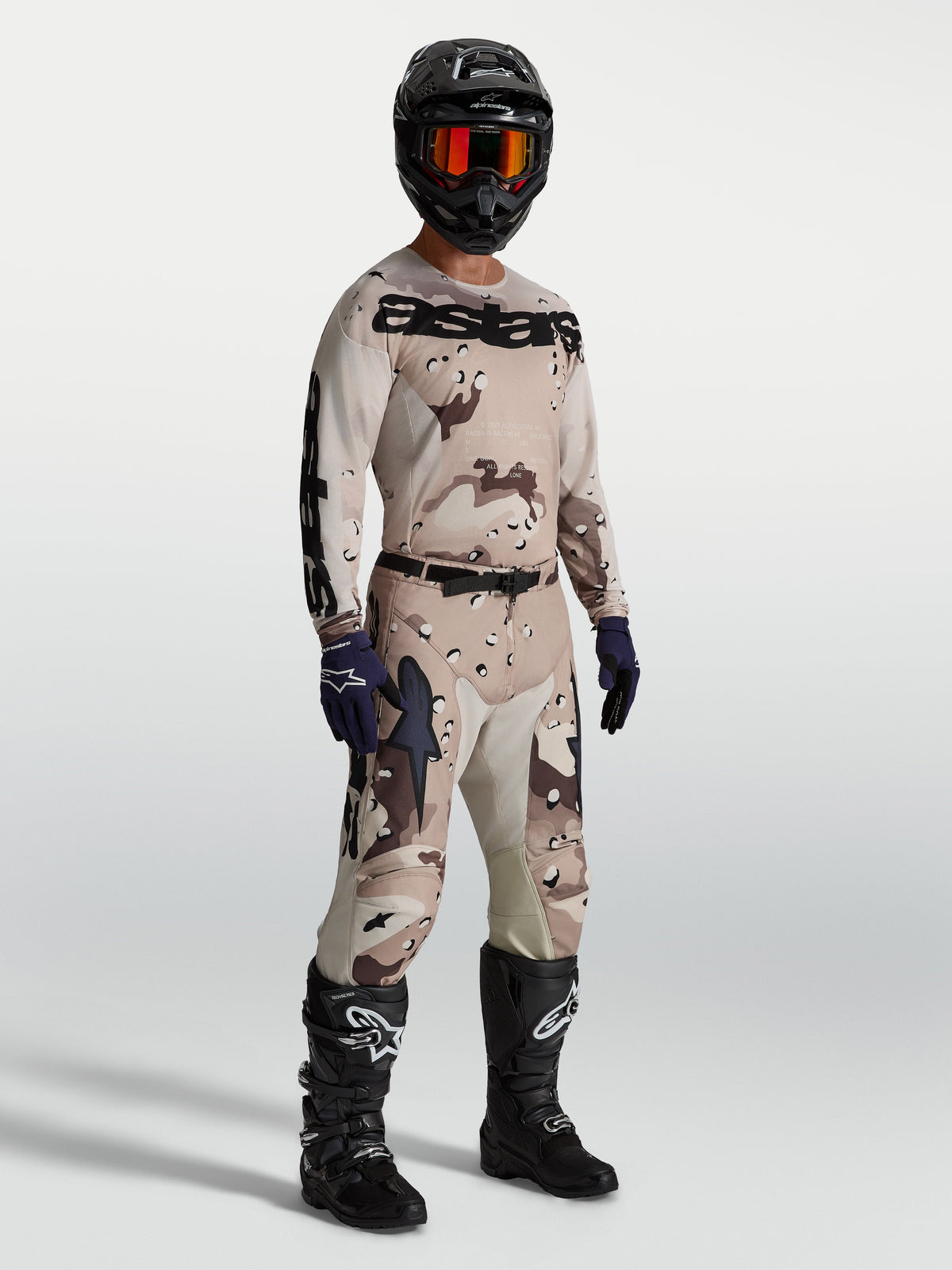 Alpinestars Racer Lone Gear Set, komplett motocrossutrustning i tan och brun camo, tröja och byxor med svarta motorcykelstövlar och hjälm, optimerad för terrängkörning