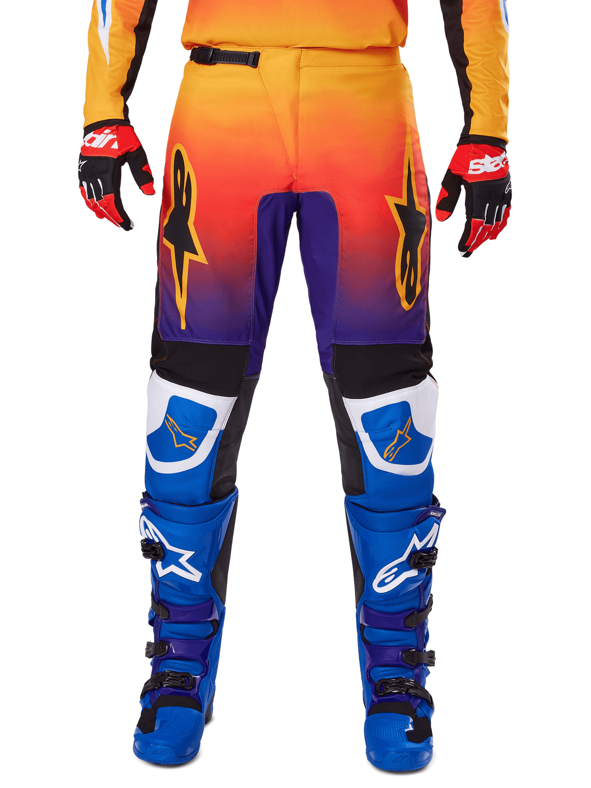 Alpinestars 2025 Fluid Wurx byxor, motocrossbyxor, flerfärgade med toning från orange till lila och blå paneler, bärs med matchande blå och lila stövlar samt röda och svarta handskar, vy framifrån med stjärnlogotyp