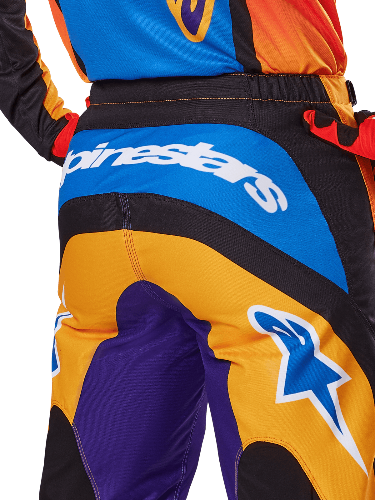 Alpinestars 2025 Fluid Wurx-byxor, motocrossbyxor, vy bakifrån i orange, blått och lila, med en vit Alpinestars-logotyp över sätet och en blå Astar-logotyp på benet, teknisk konstruktion för terrängkörning