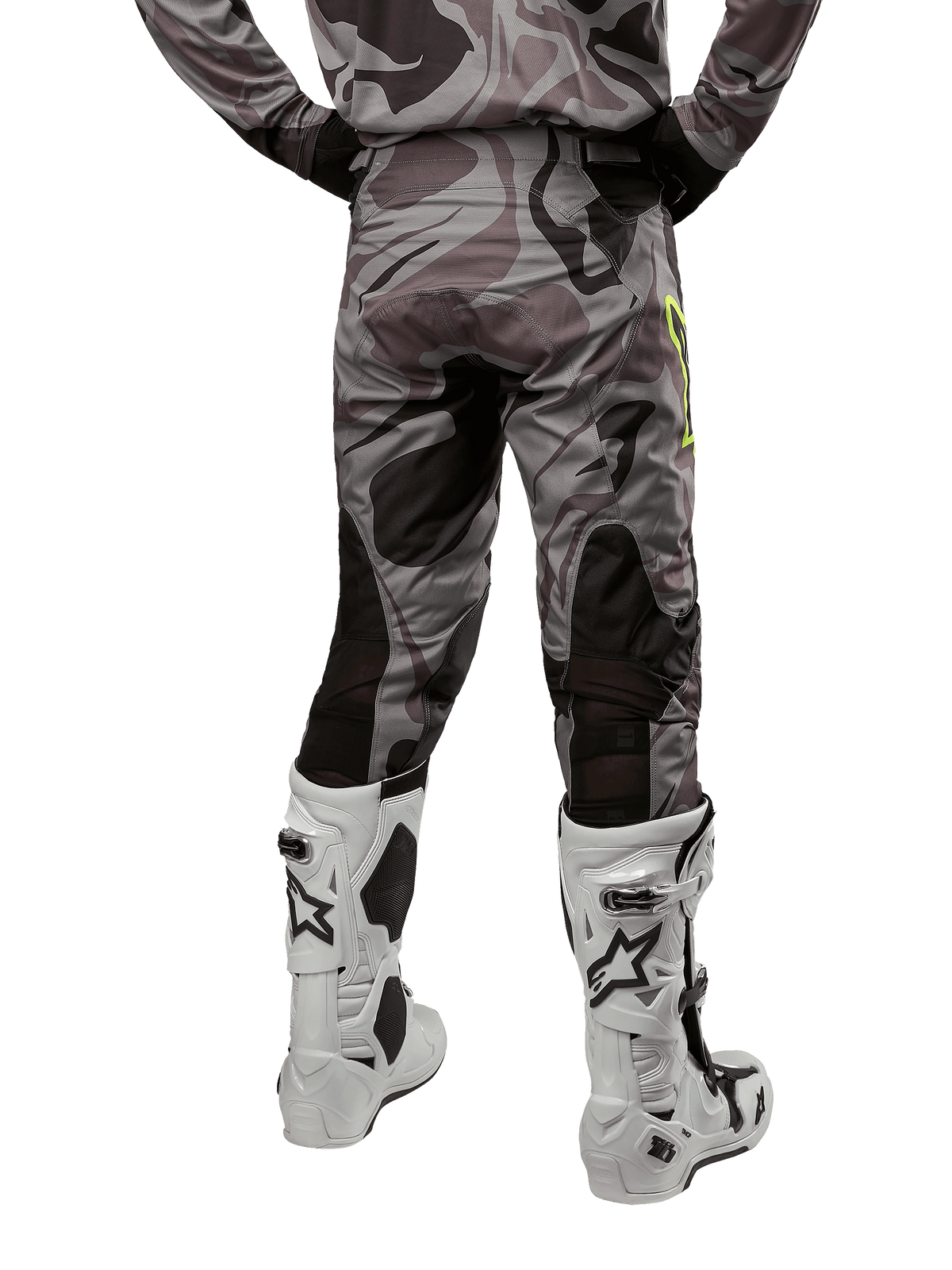 Alpinestars 2024 Racer Tactical byxor, motocrossbyxor, Cast Gray Camo Magnet, baksida som visar kamouflagemönstret och svarta andningsbara stretchzoner, bärs med vita och svarta motocross-stövlar, designade för terrängkörning