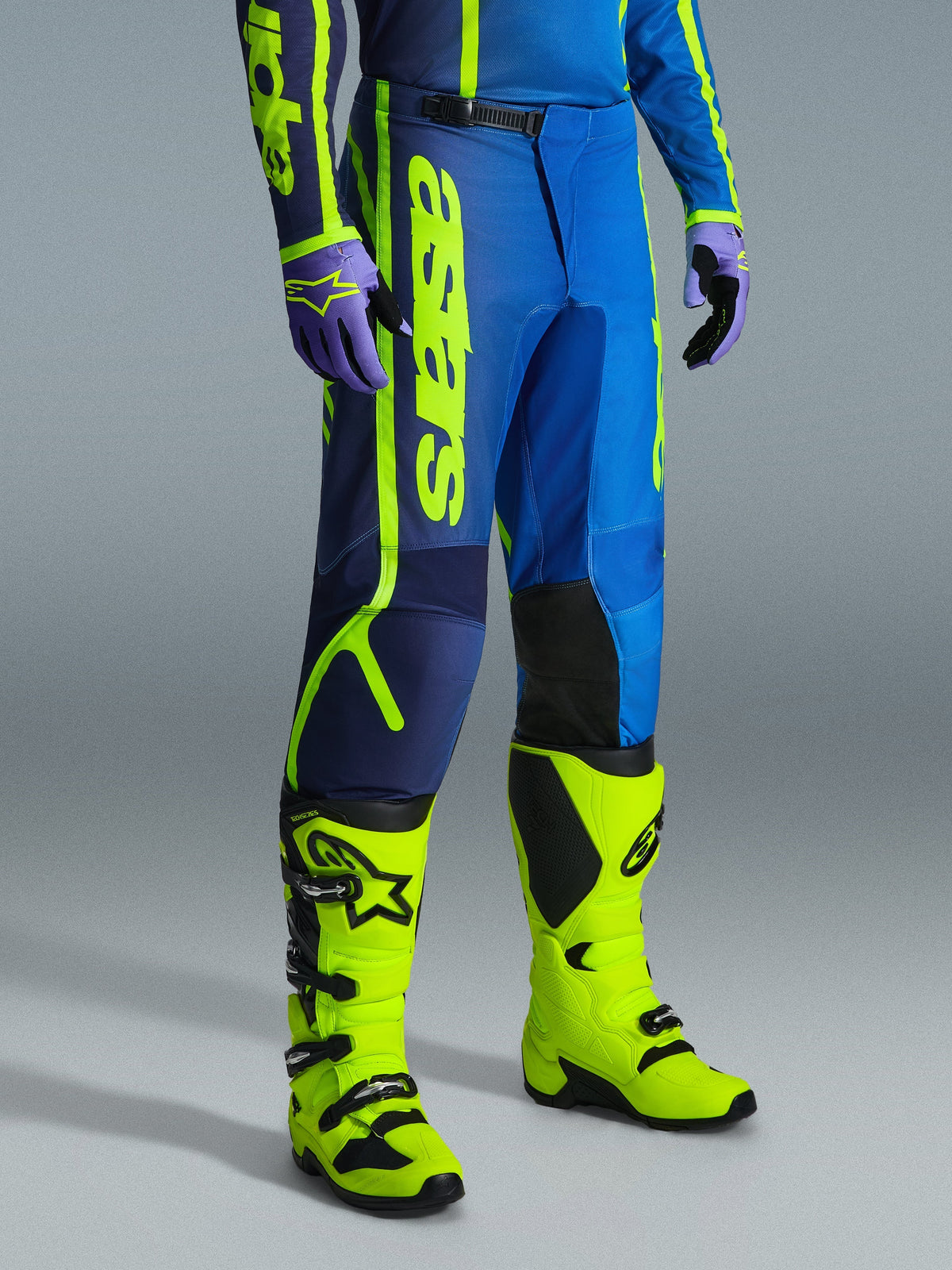 Alpinestars 2026 Fluid Apex byxor, motocrossbyxor, blå och neongula, bärs med matchande handskar och starkt neongula stövlar, med framträdande vertikal logotyp, förstärkta knäpaneler och en säker midjestängning med spärrspänne.