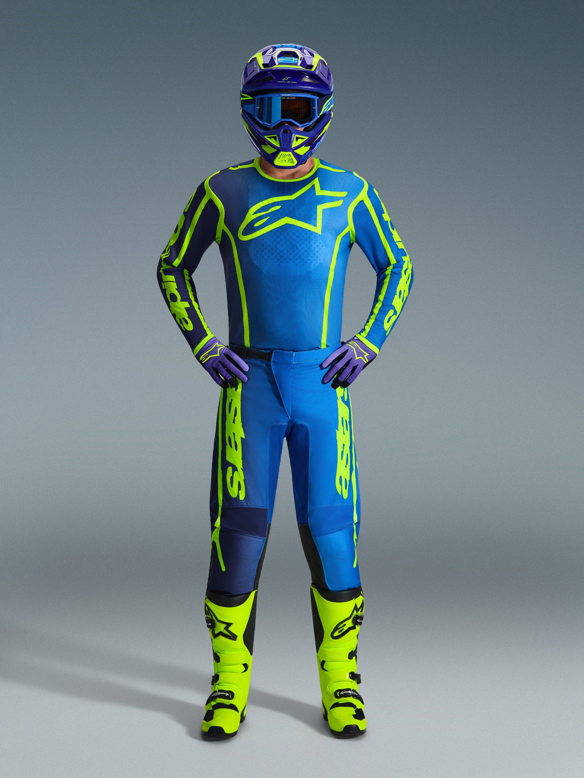 Alpinestars 2026 Fluid Apex byxor, motocrossbyxor, blå och neongula, bärs av en förare med matchande tröja, hjälm, handskar och stövlar, med framträdande gul Alpinestars-logotyp på blå bas, koordinerad outfit för terrängkörning