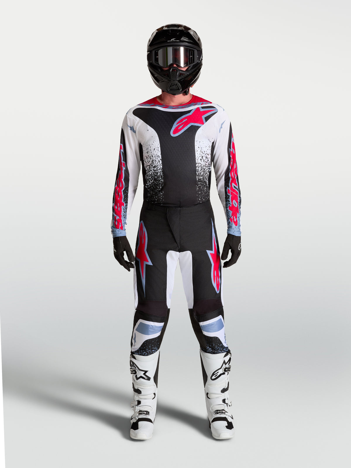 Alpinestars 2027 Fluid Drag Pants, black and white motocross gear with red and light blue accents, shown as a full gear set.