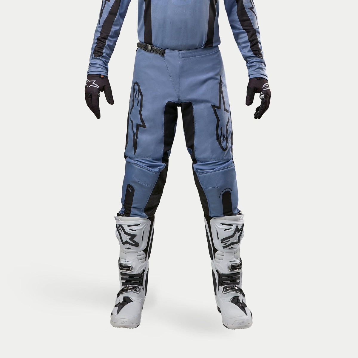 Alpinestars 2024 Fluid Lurv byxor, motocrossbyxor, ljusblå och svarta, bärs med vita och svarta racingstövlar och matchande handskar, med framträdande svarta stjärnlogotyper på låren, ergonomisk design för terrängkörning