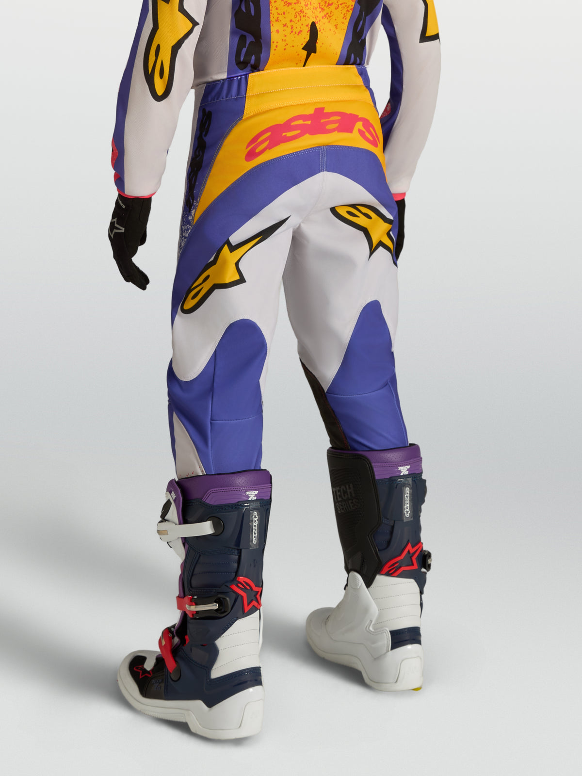 Alpinestars 2027 Ungdom Fluid Drag byxor, blåa och vita motocrossbyxor för barn med gula detaljer, 600D polytyg och stretchpaneler för terrängkörning, vy bakifrån