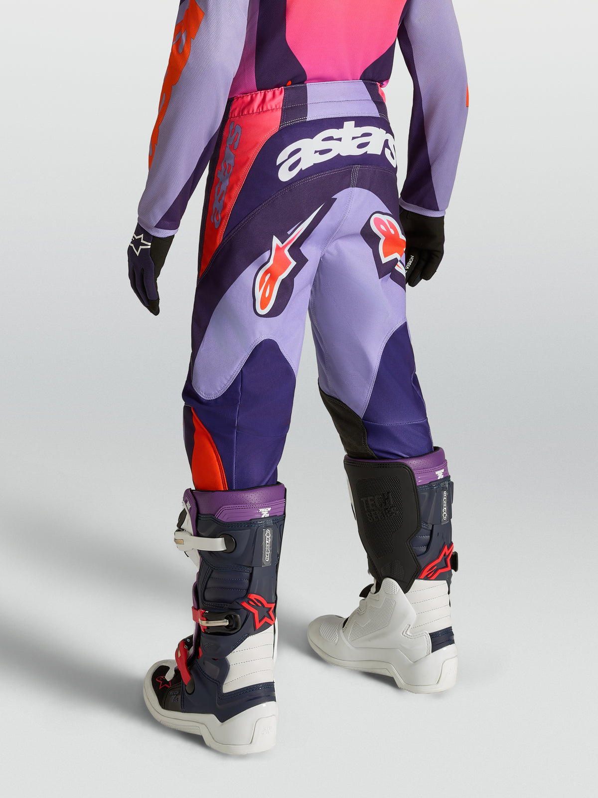 Alpinestars 2027 Ungdom Fluid Hunt byxor, motocrossbyxor i lila och rosa, slitstarkt 600D polytyg, vy bakifrån på modell.