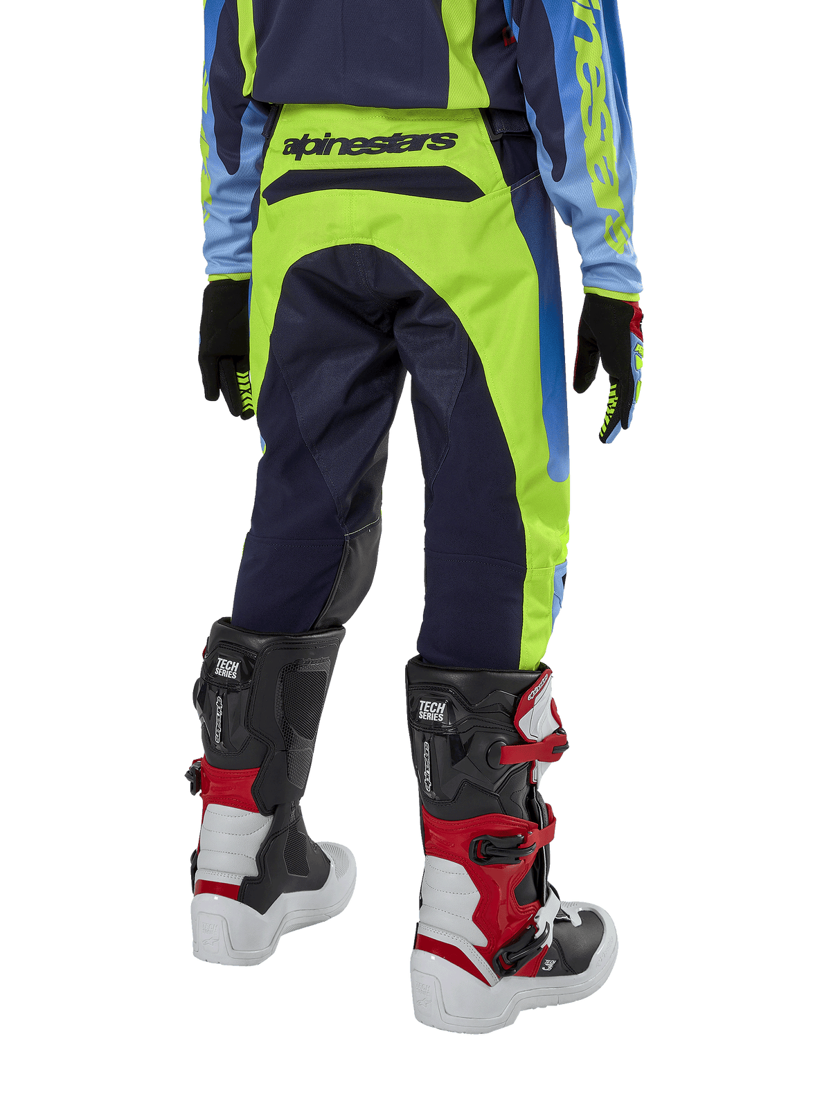 Alpinestars Youth 2024 Racer Hoen byxor, motocrossbyxor, gul fluo och mörkblå (Blue Night Navy), vy bakifrån som visar tydlig Alpinestars-logotyp på linningen, bärs med svarta och röda Tech Series-stövlar och matchande tröja, hållbar sportpassform för terrängkörning för ungdomar