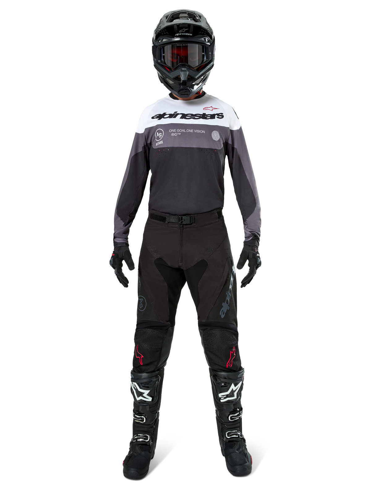 Motocrossförare i komplett racingutrustning, Pro-Dura Jersey i Black Magnet White med vitt övre bröstparti och grå detaljer, matchad med svarta byxor, svart hjälm med mörka goggles, vita och svarta stövlar och svarta handskar, koordinerad outfit för enduro och terrängkörning