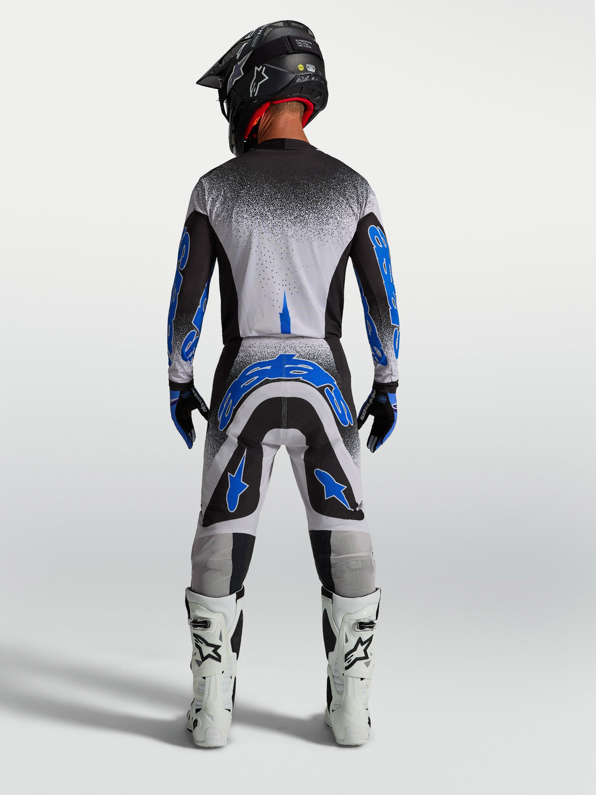 Alpinestars Supertech Hiten AFD tröja och utrustningsset, herrmotocrossutrustning i svart, vitt och blått, vy bakifrån med matchande hjälm och vita stövlar.