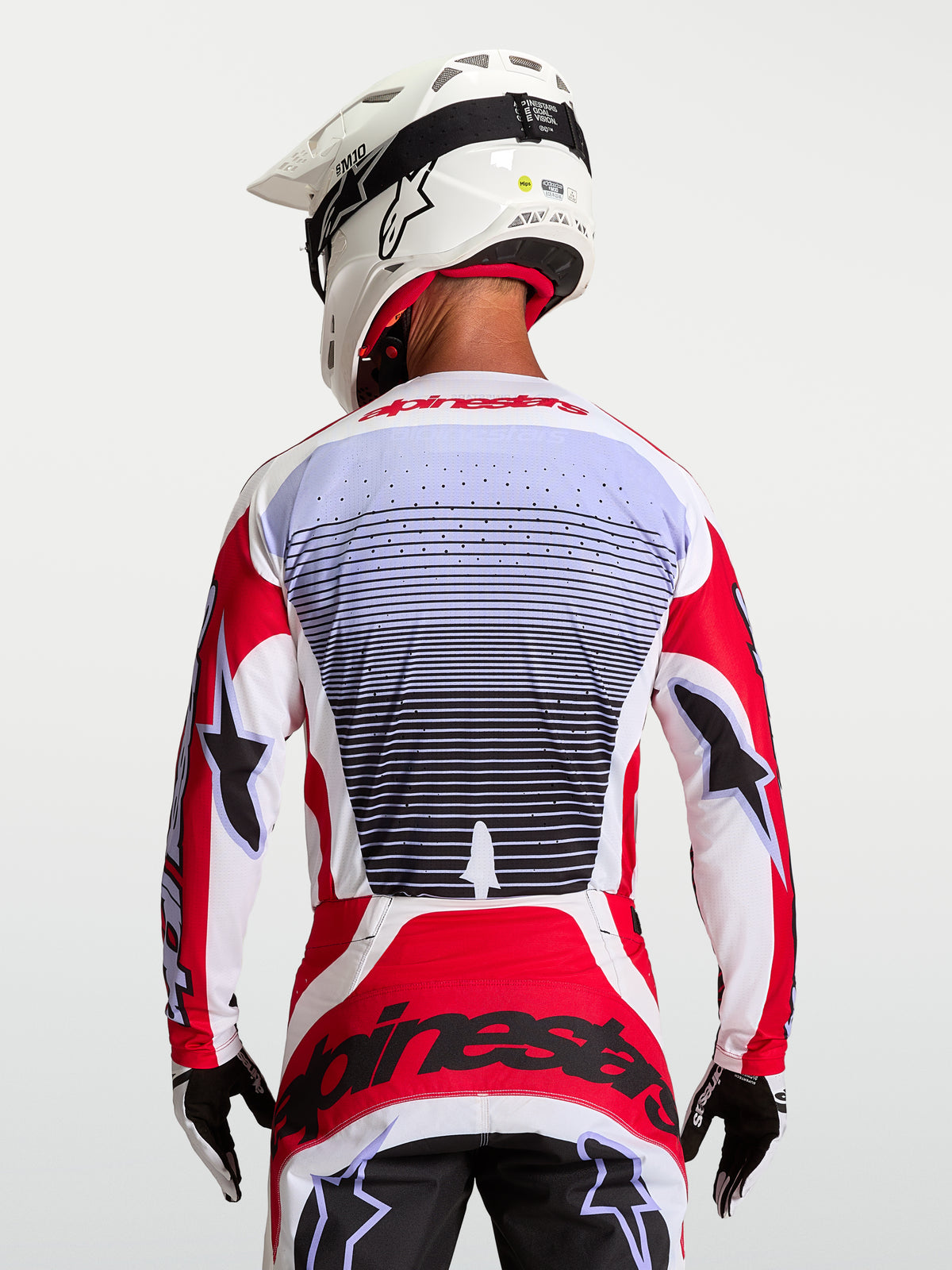 Alpinestars Techstar Maven tröja, motocross-racingtröja i rött och vitt, andningsbart stretchtyg, vy bakifrån på förare.