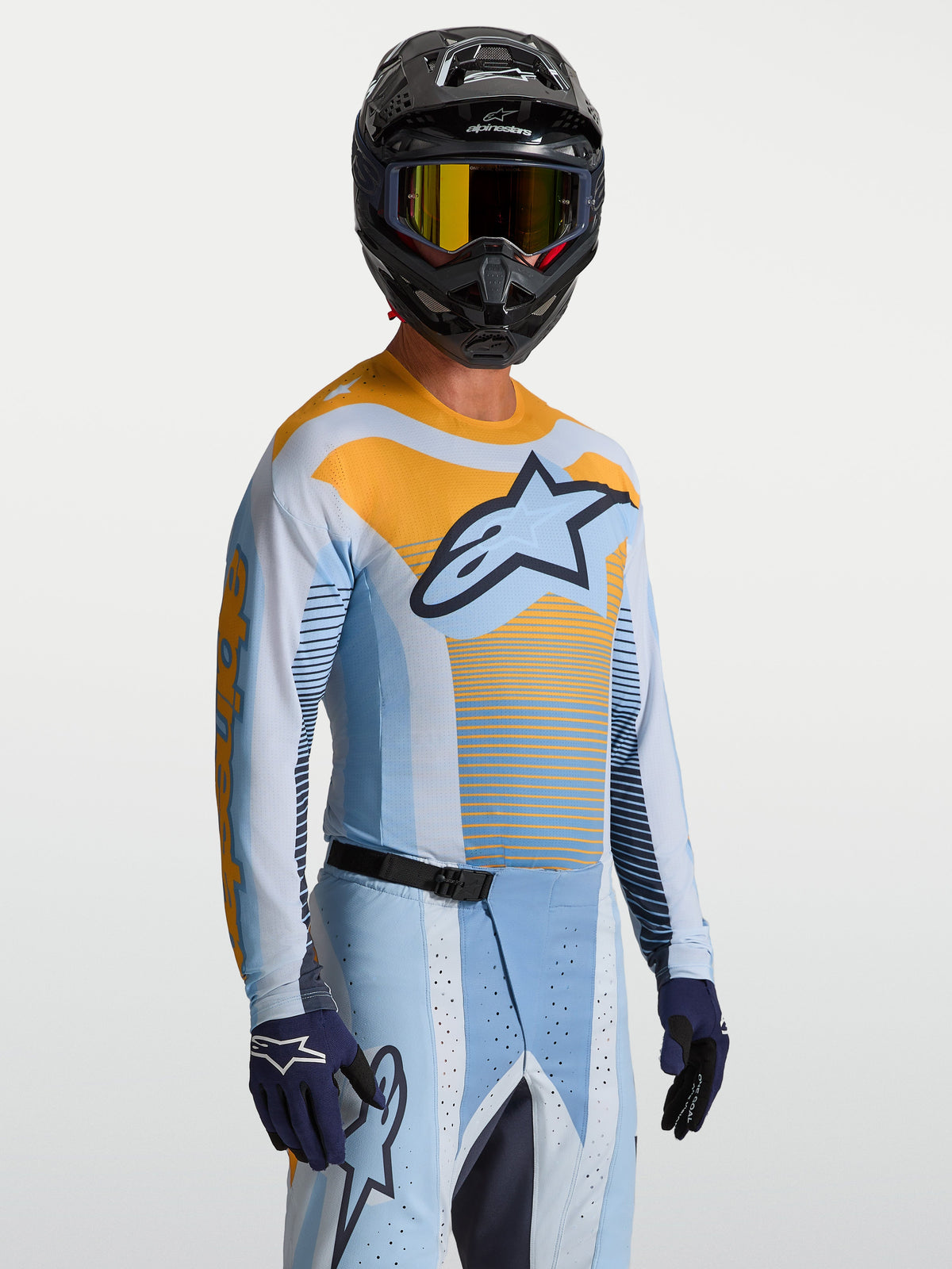 Alpinestars Techstar Maven tröja, motocrosströja för herrar, ljusblå och orange, atletisk racingpassform för terrängkörning, visas på modell.