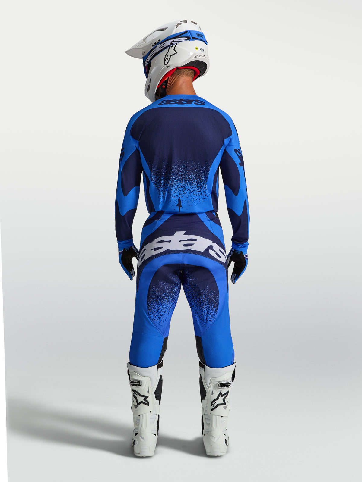 Alpinestars Techstar Swan tröja och gear set, blå och mörkblå motocrossutrustning för herr, vy bakifrån med vita racingstövlar.