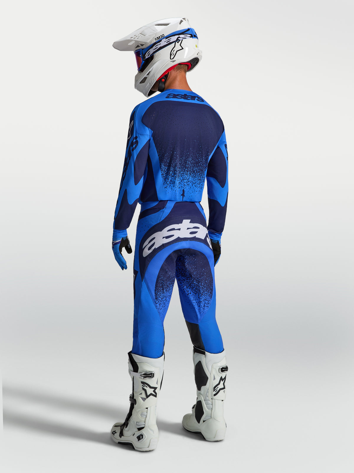 Alpinestars Techstar Swan motocross-ställ, blått och mörkblått med atletisk passform, vita stövlar och hjälm.