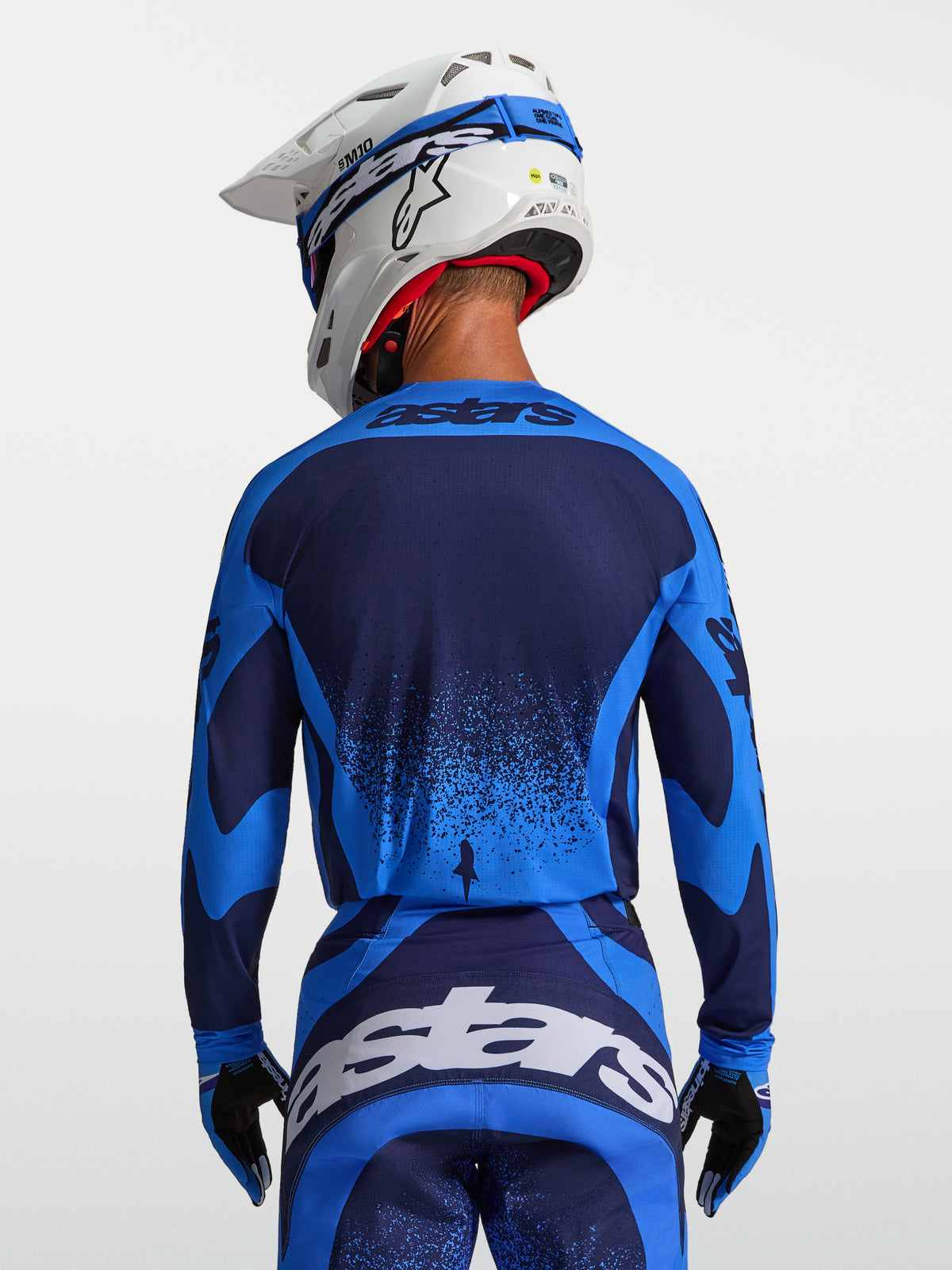 Alpinestars Techstar Swan tröja, motocrosströja för herr, blå och mörkblå, atletisk tävlingspassform med förlängd rygg, buren av modell bakifrån.