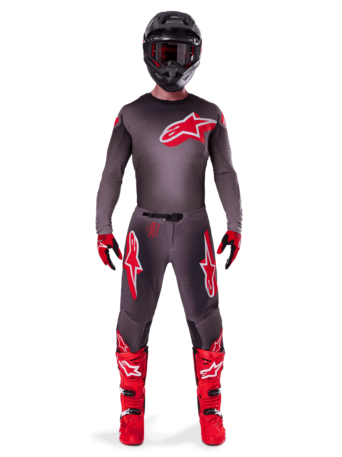 Motocrossförare i komplett tävlingsutrustning, 2025 Supertech Lipan-tröja i Smoke Bright Red, matchande grå byxor med röda logotyper, klarröda stövlar, svart hjälm med goggles och röda och svarta handskar, professionell motocrossoutfit.