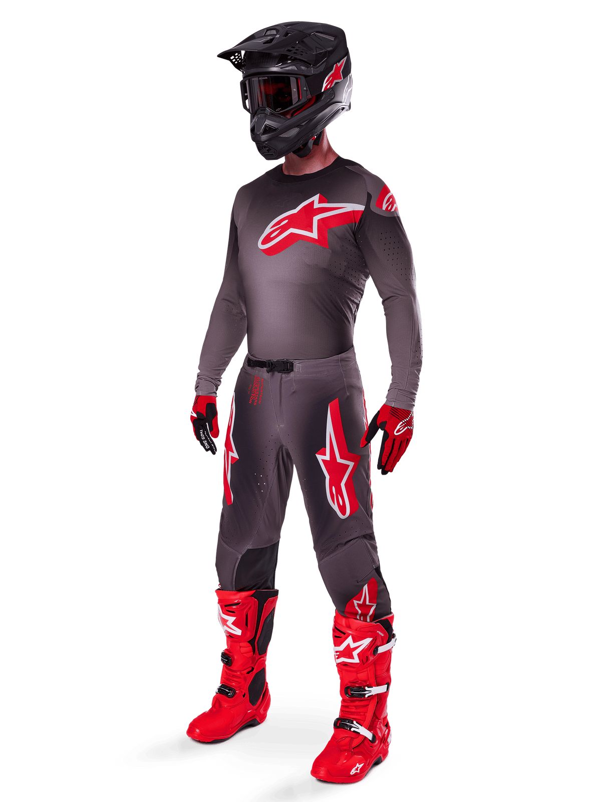 Motocrossförare i komplett racingutrustning, 2025 Supertech Lipan-tröja i Smoke Bright Red, matchande grå byxor med röd grafik, svart hjälm med röda detaljer, klarröda stövlar och röd-svarta handskar, professionell outfit för terrängkörning