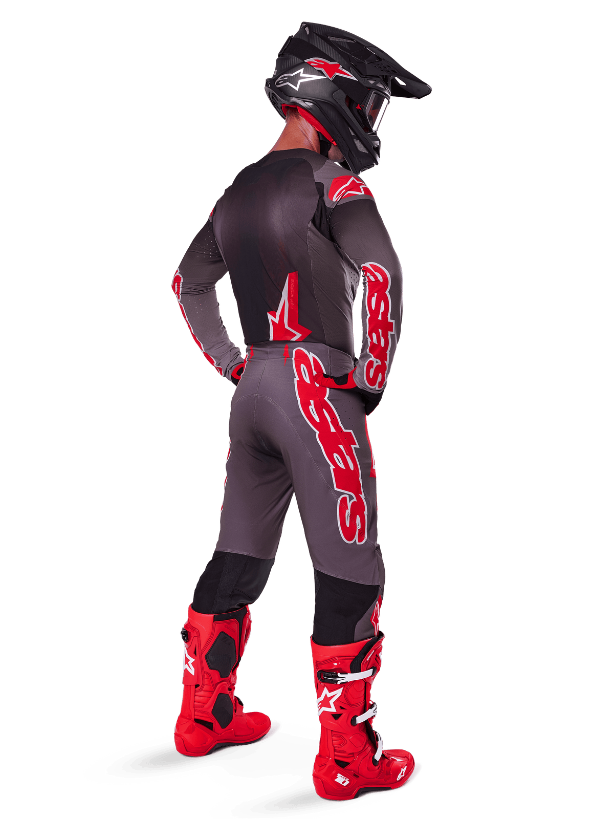 Motocrossförare bär 2025 Supertech Lipan Jersey, Smoke Bright Red, sedd bakifrån med matchande grå och röda byxor, klaröda stövlar, svart hjälm med röda detaljer och röda goggles, koordinerat professionellt utrustningsset för terrängkörning