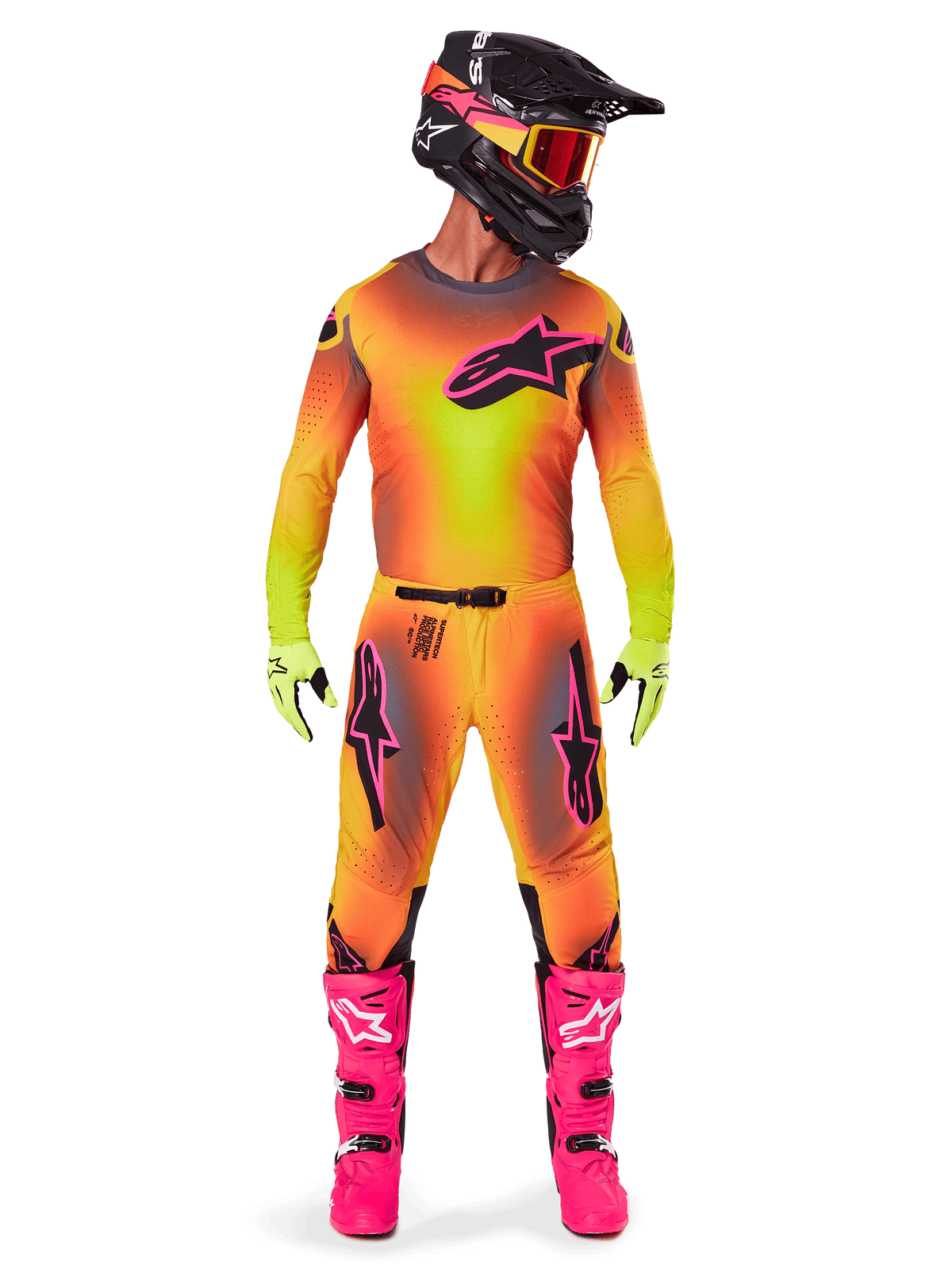 Motocrossförare i komplett racingutrustning, 2025 Supertech Lipan tröja och byxor i en gul och orange färgtoning med rosa detaljer, svart hjälm med matchande rosa grafik, starkt rosa stövlar och limegröna handskar, koordinerad Alpinestars-outfit för terrängkörning.