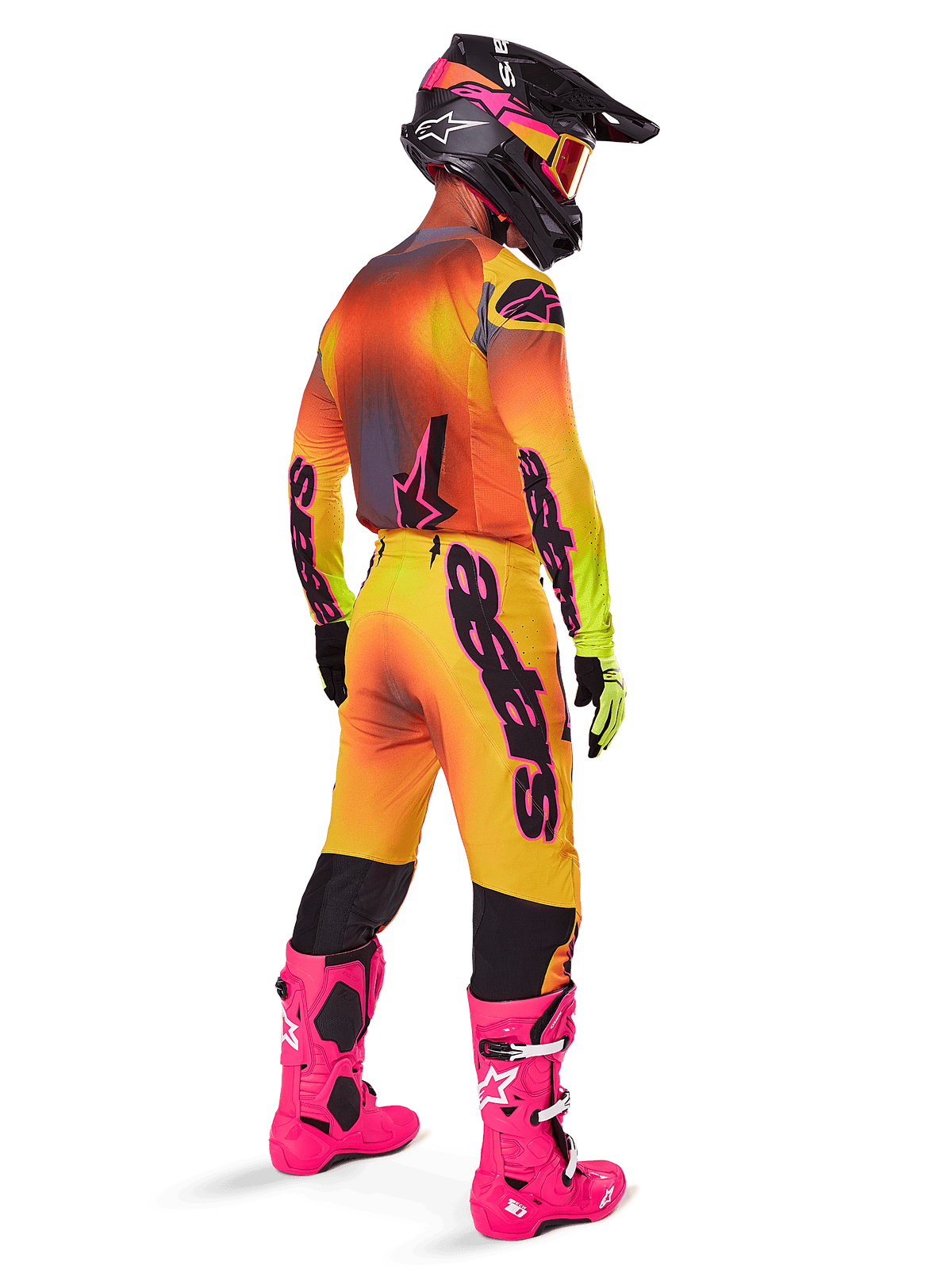 Motocross rider from behind wearing the Alpinestars 2025 Supertech Lipan Gear Set, yellow and orange gradient jersey with pink accents, matching pants, bright pink boots, and a black helmet with pink and yellow graphics, coordinated outfit for professional racing