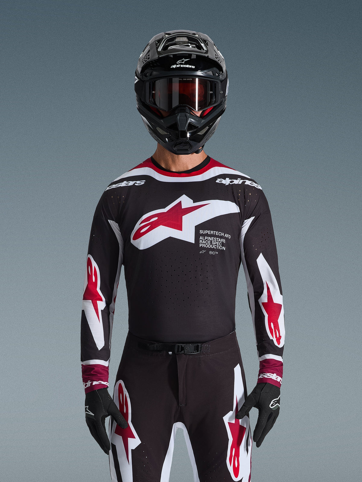 Alpinestars 2026 Supertech AFD Vista utrustningsset, motocross-set, svart tröja med röda och vita logotyper och 'Supertech AFD'-grafik, matchande svarta byxor med röda detaljer, svart hjälm med röda goggles, koordinerad professionell racingoutfit