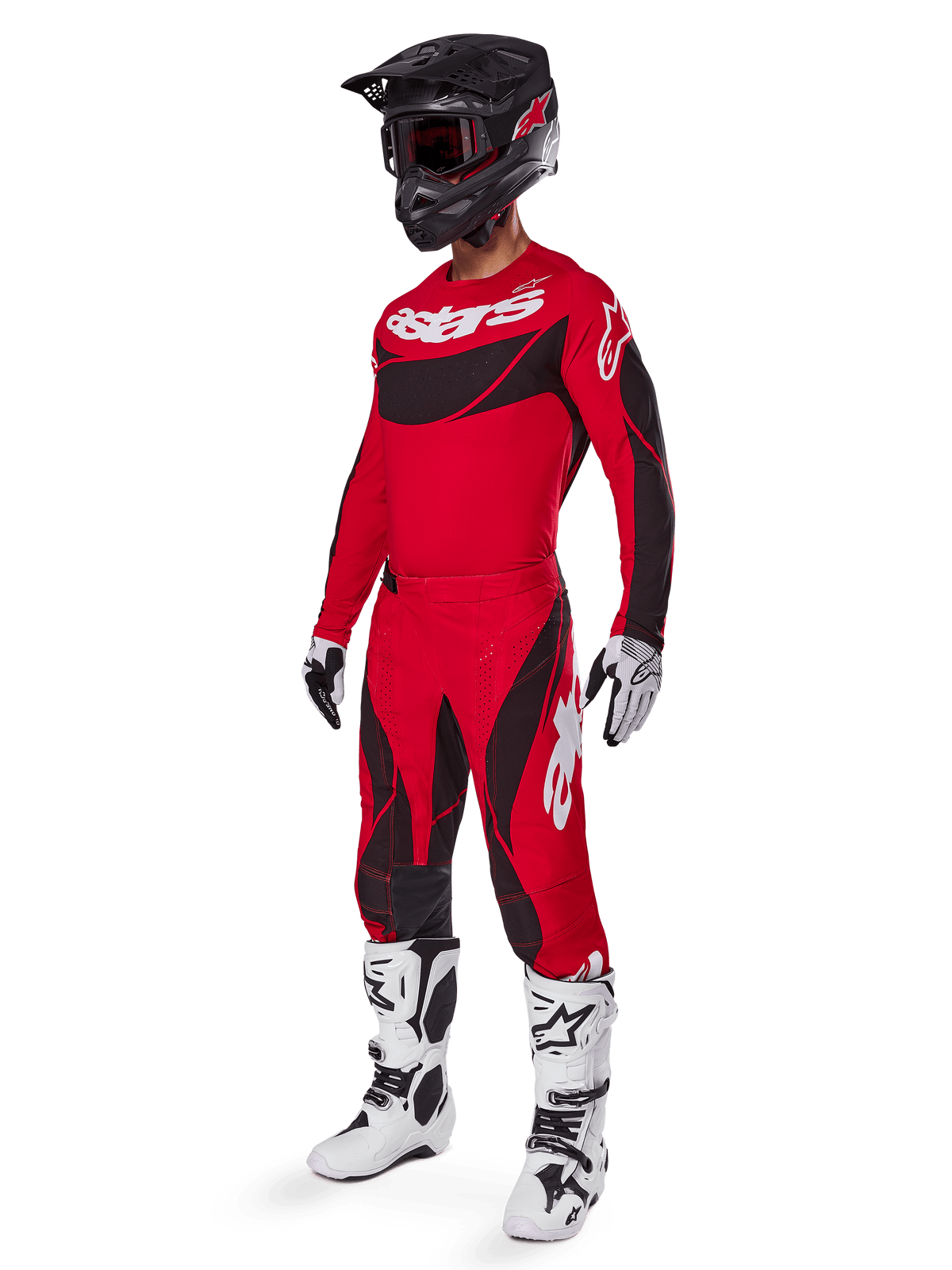 Helkroppsbild av en motocrossförare i 2025 Techstar Dreem-utrustningsset i klarrött och svart, bestående av en MX-tröja med vit logotyp, matchande stretch-ripstopbyxor, en svart hjälm med röda goggles, vita och svarta handskar och vita Tech-stövlar, specialiserad racingoutfit för terrängkörning.