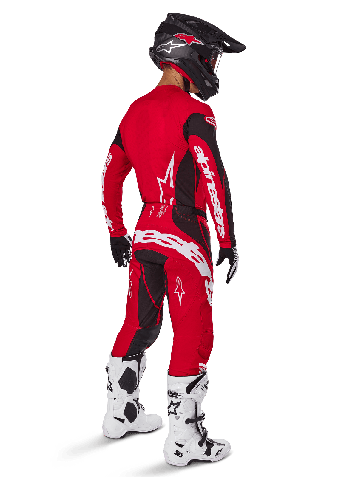 Motocrossförare iklädd Alpinestars 2025 Techstar Dreem-utrustningsset i klarrött och svart, vit logotyp på tröjan och byxorna, matchat med en svart hjälm, vita och svarta stövlar samt svarta och vita handskar, sedd snett bakifrån.