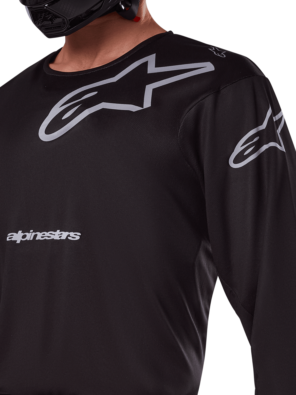 Alpinestars 2025 Racer Graphite-tröja, svart och grå, närbild av förare i motocrosströja, med grå Alpinestars-profilering och A-star-logotyper, tekniskt poly-material för terrängkörning