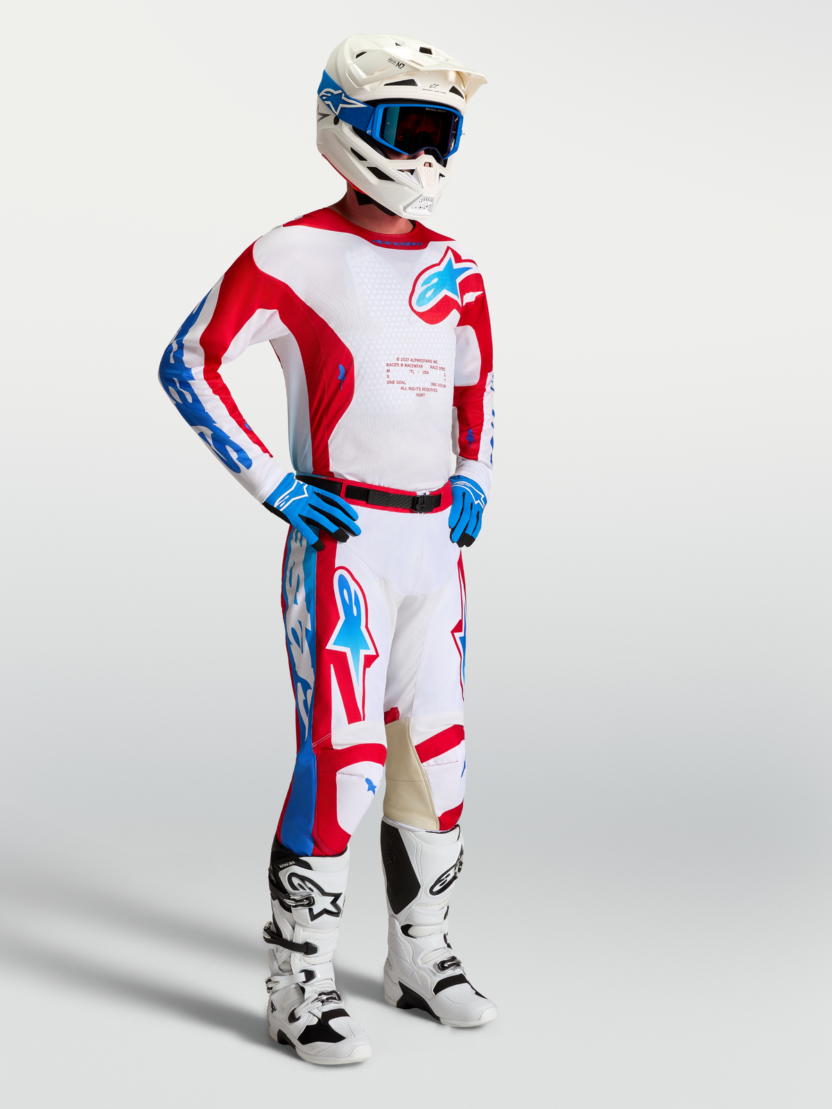Alpinestars Racer Hunt gear set, röda och vita motocrossbyxor och tröja på modell för prestandainriktad terrängkörning.