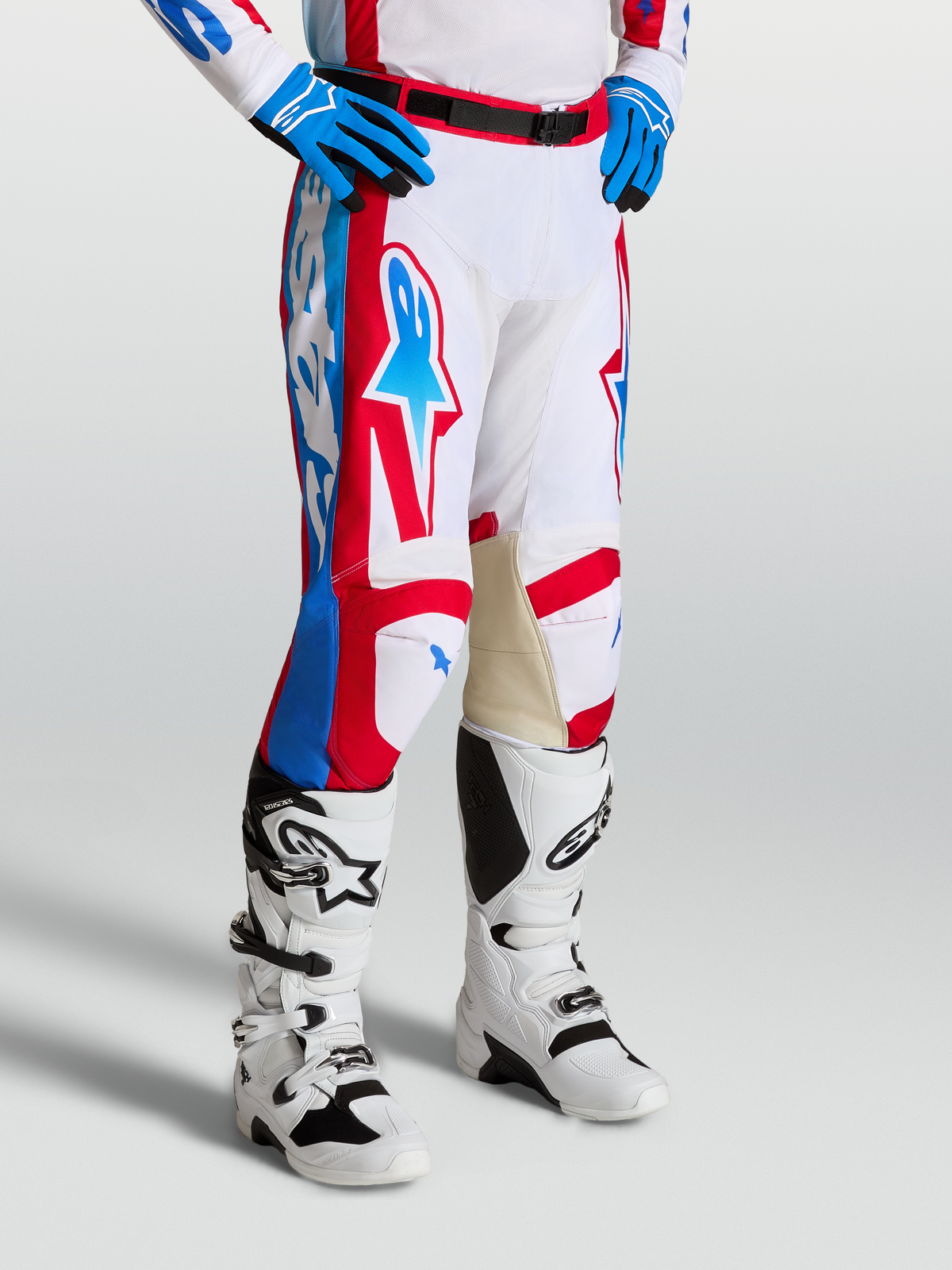 Alpinestars Racer Hunt byxor, motocrossbyxor i vitt, rött och blått med förböjda ben och läderpaneler på knänas insidor