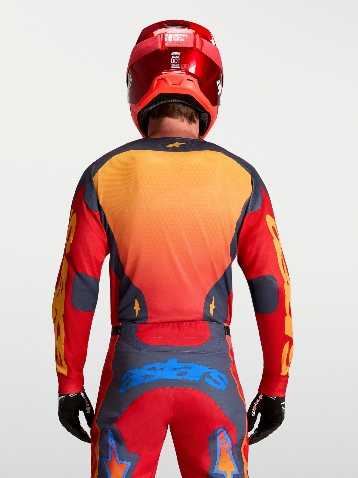 Alpinestars Racer Hunt tröja, MX-utrustning för herr, röd och grå med gula detaljer, sedd bakifrån på modell, lätt och ventilerat material för motocross.