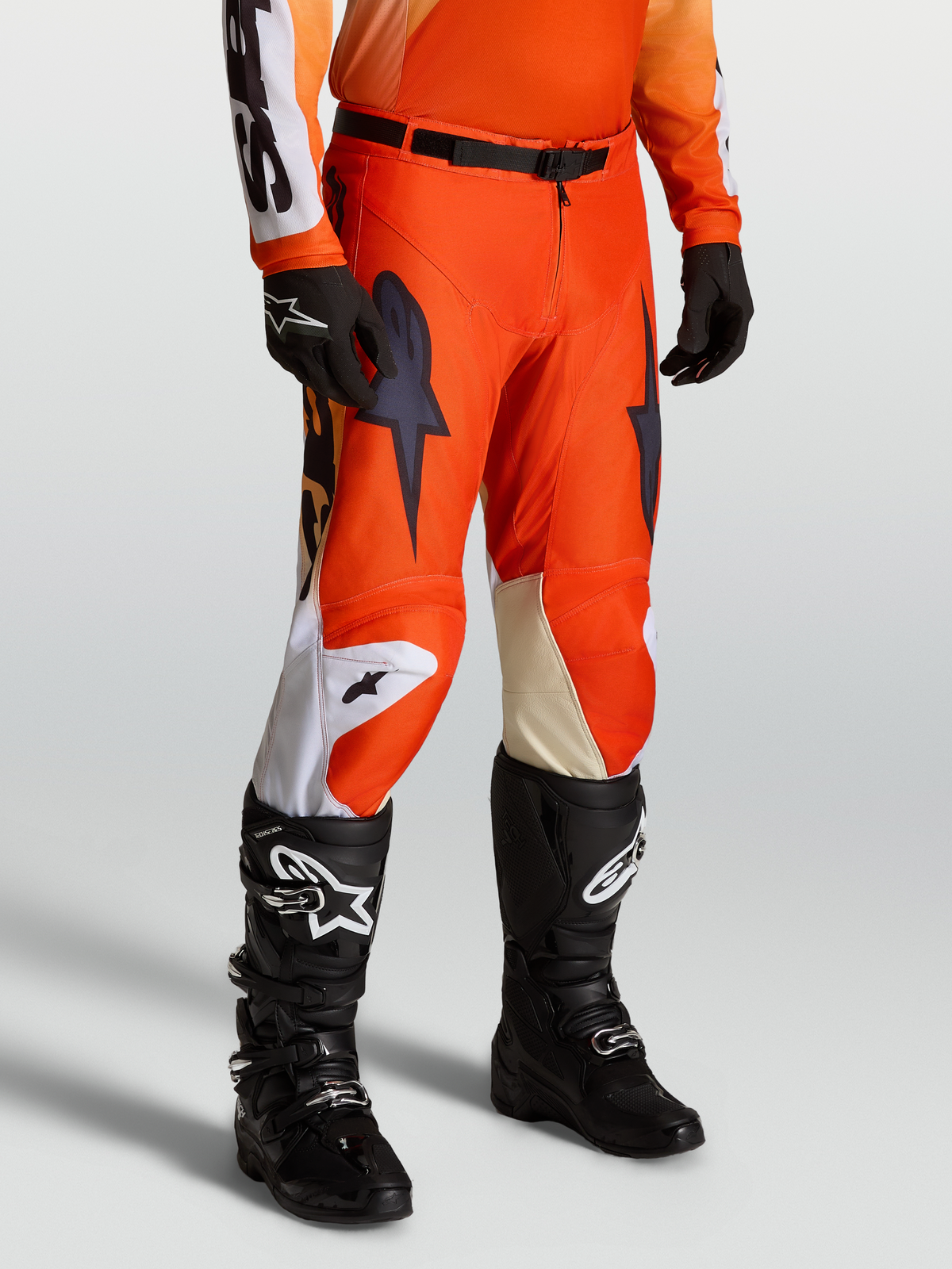 Alpinestars Racer Amber byxor, röda och svarta motocrossbyxor, bärs av modell med matchande tröja, handskar och Tech Series motorcykelstövlar.