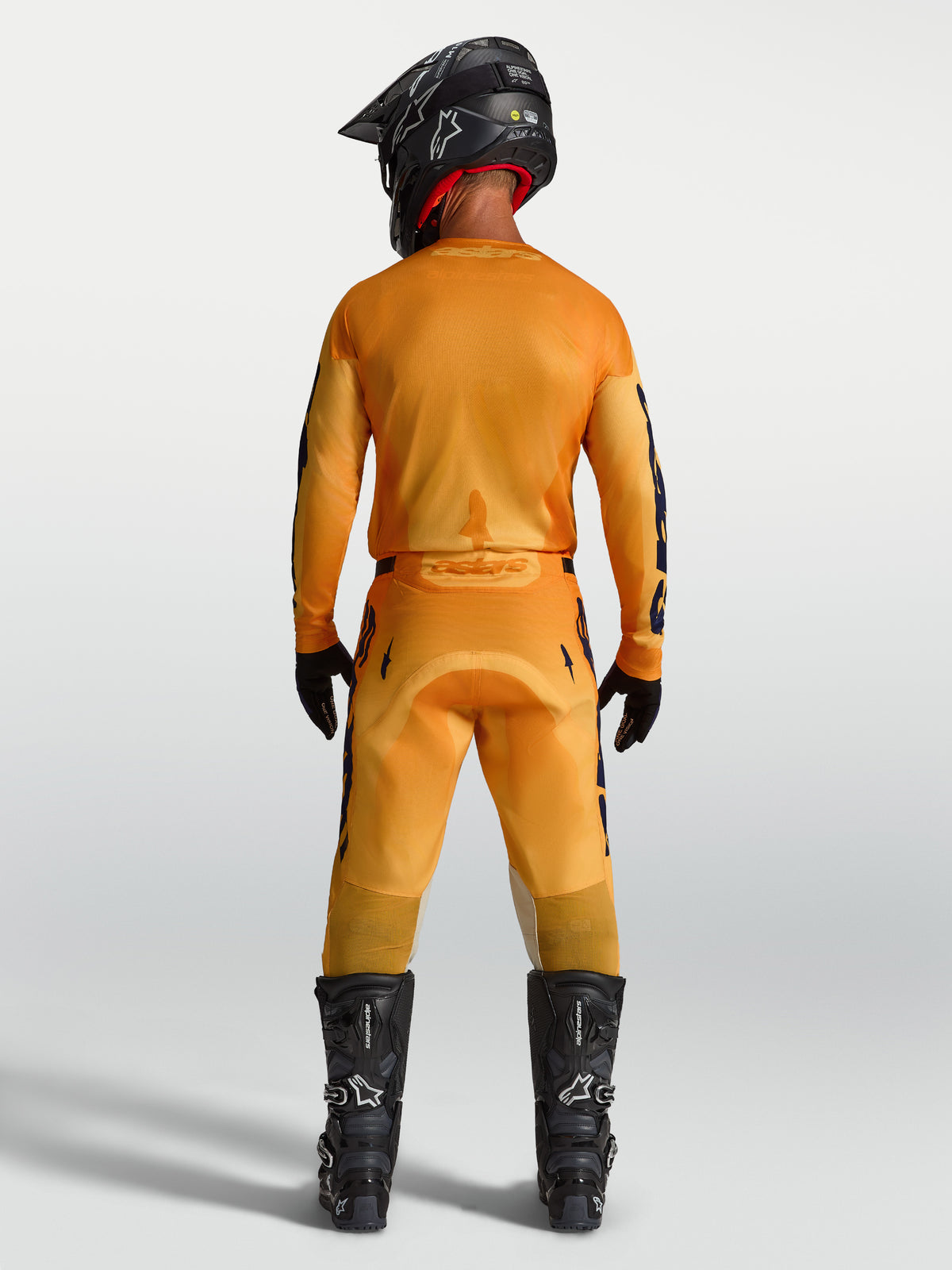 Alpinestars 2027 Racer Amber tröja och utrustningsset, motocrossutrustning för herr, orange och mörkblå, vy bakifrån på modell med komplett racingutrustning