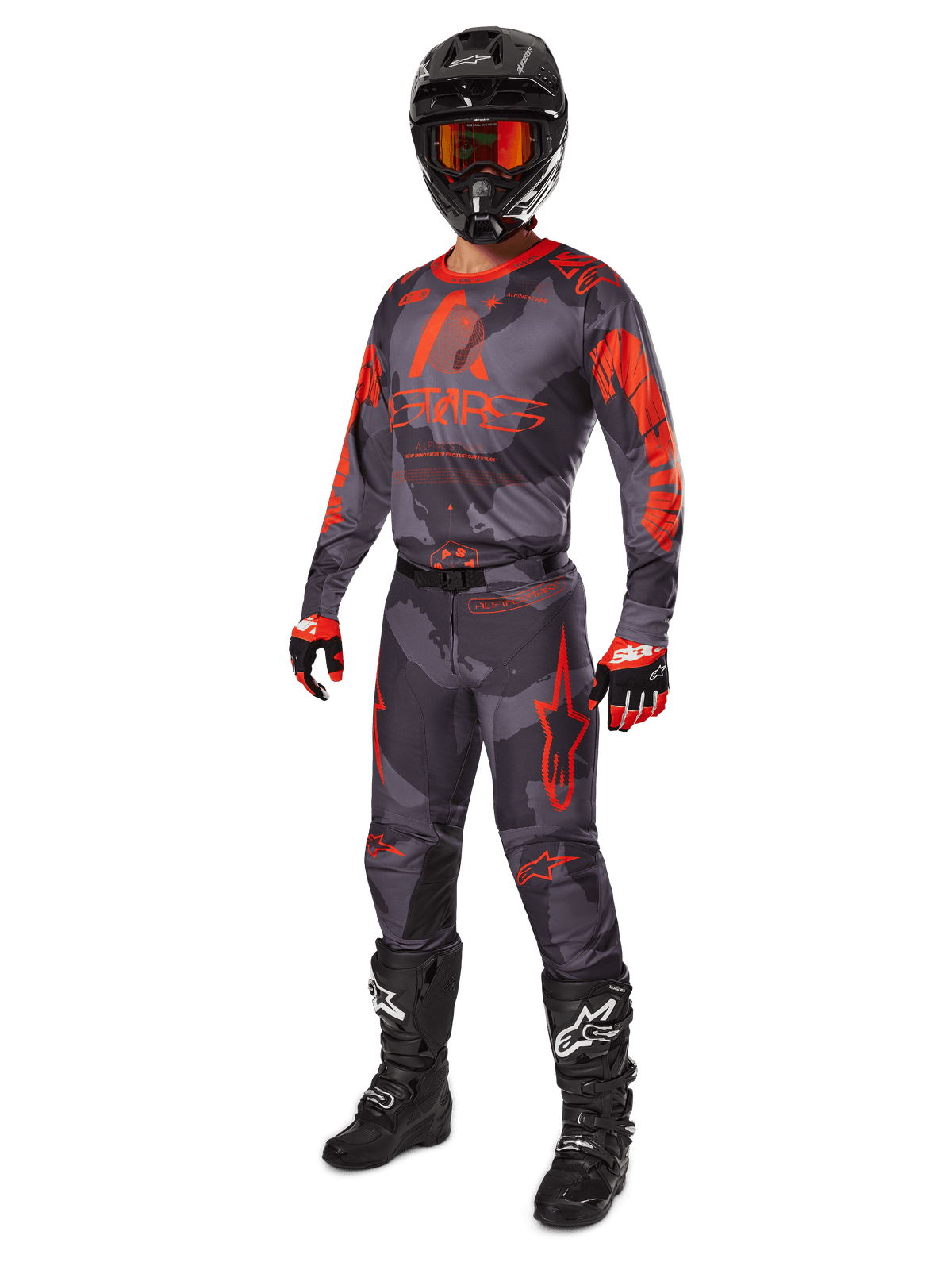 Motocrossförare i komplett racingutrustning, Alpinestars 2025 Racer Hollow-tröja och byxor i Gray Camo Orange Fluo, svart hjälm med orangea goggles, svarta och röda handskar samt svarta stövlar med vita logotyper, matchande prestandautrustning för terrängkörning