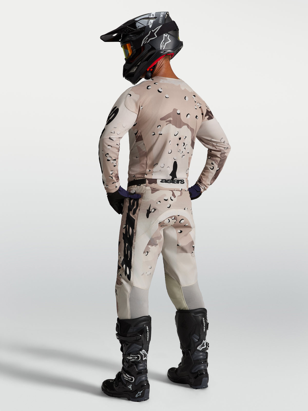 Alpinestars Racer Lone tröja, motocrosströja för herr, beige ökenkamouflage och svart, lätt fukttransporterande polytyg, modell sedd bakifrån med matchande byxor och hjälm för terrängkörning