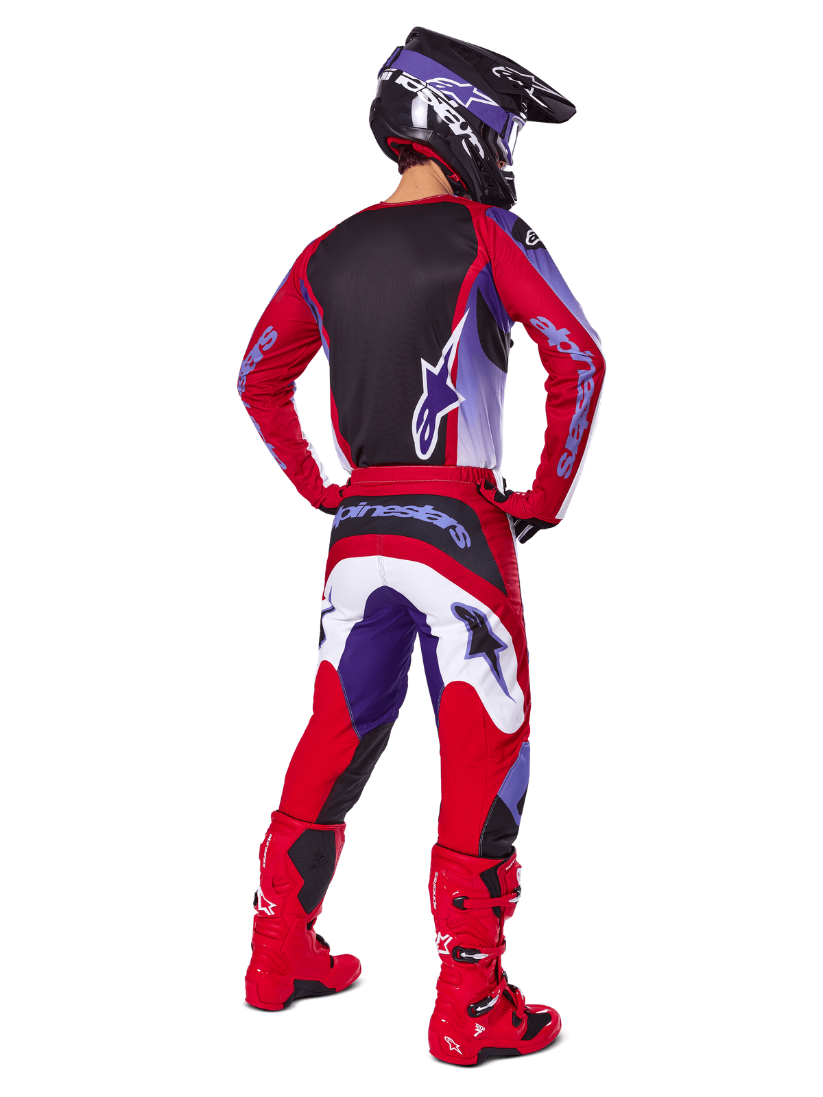 Motocross rider from behind wearing the Alpinestars 2025 Fluid Wurx Gear Set, Purple Bright Red jersey with black back panel, matching motocross pants with white and purple accents, bright red boots, and black helmet, professional off-road racing outfit