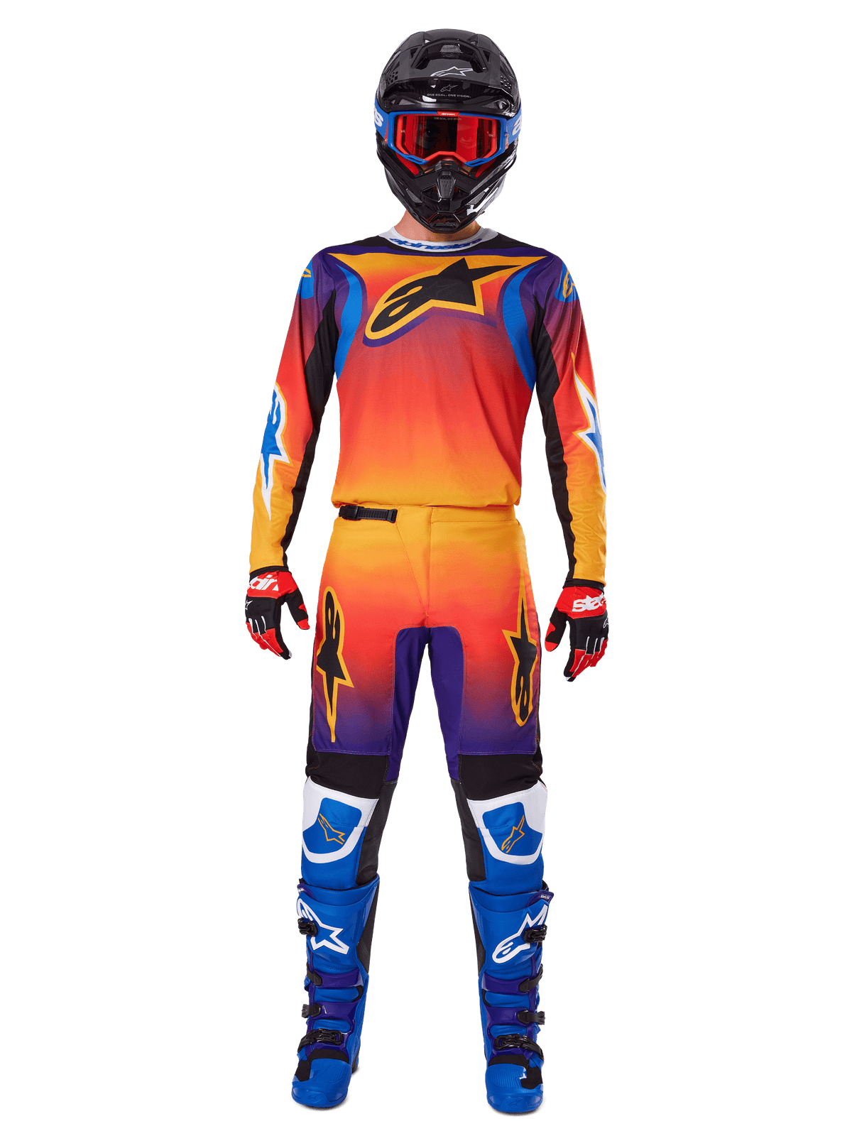 Motocrossförare klädd i Alpinestars 2025 Fluid Wurx utrustningsset, med en livfull gradient i orange, gult och blått på tröjan och byxorna, svarta Alpinestars-logotyper, kombinerat med blå racingstövlar, röda och svarta handskar samt en svart hjälm med röda goggles, komplett koordinerad outfit för terrängkörning