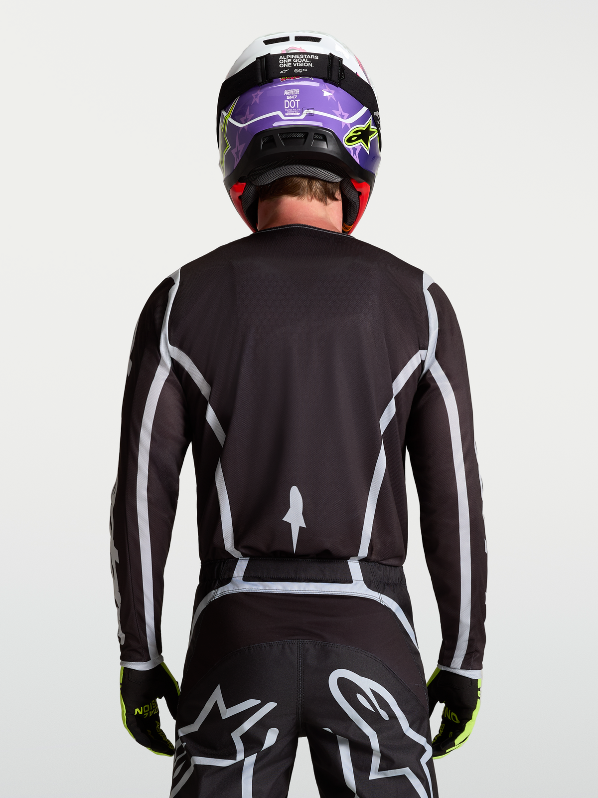 Alpinestars Fluid Apex V2 motocrosströja för herr, svart och silver, vy bakifrån på modell med ergonomisk passform.