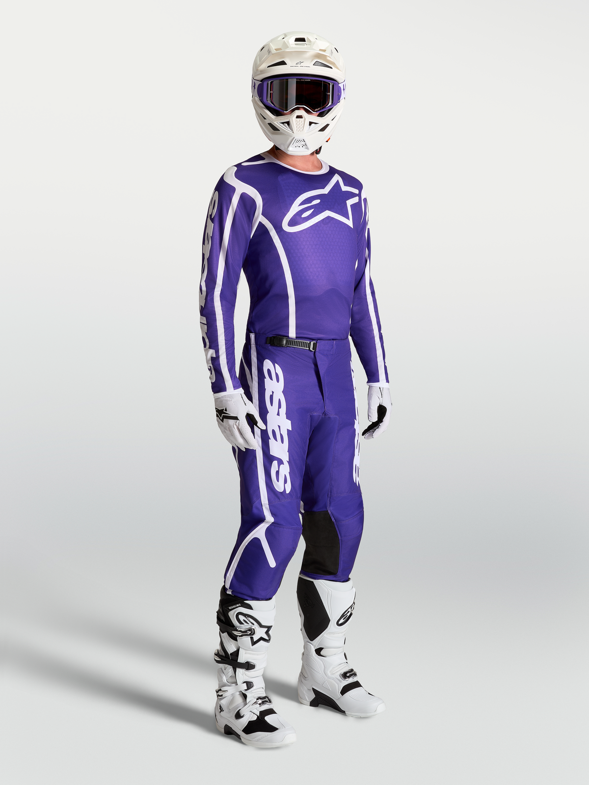 Alpinestars Fluid Apex V2 tröja och matchande byxor, mörkblå och vit motocrossutrustning på modell med vit hjälm och stövlar.
