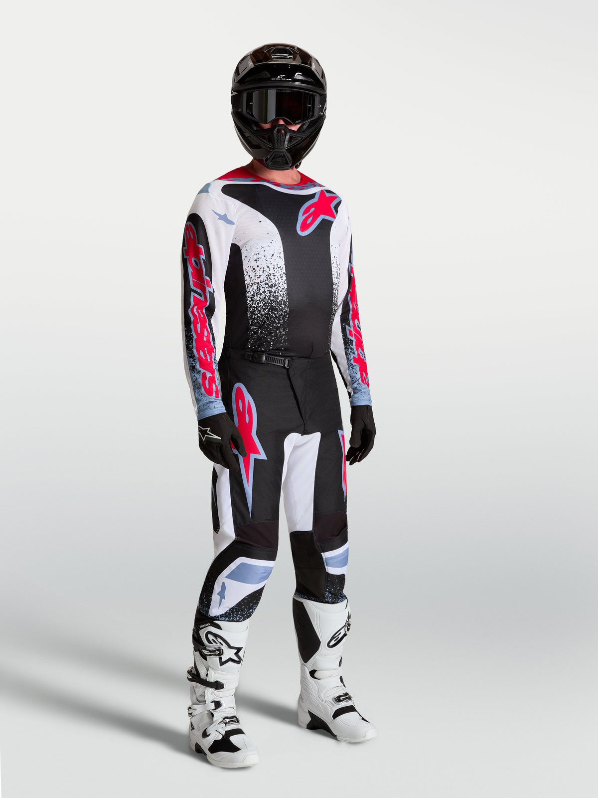 Alpinestars 2027 Fluid Drag MX-utrustningsset, motocross-outfit för herrar, svart och vit med röd grafik och vita stövlar.