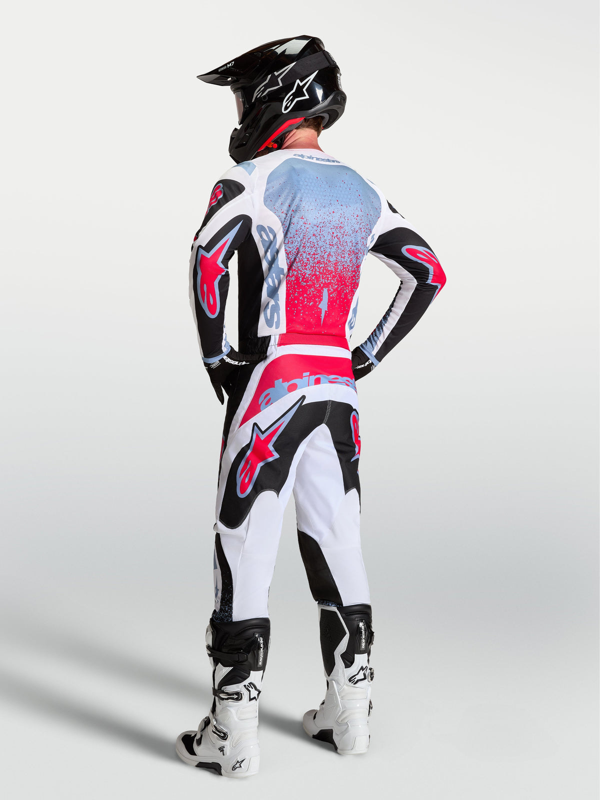 Alpinestars 2027 Fluid Drag MX-utrustningsset, svart, vit och röd, grafik med sprayeffekt, vy bakifrån för terrängkörning.