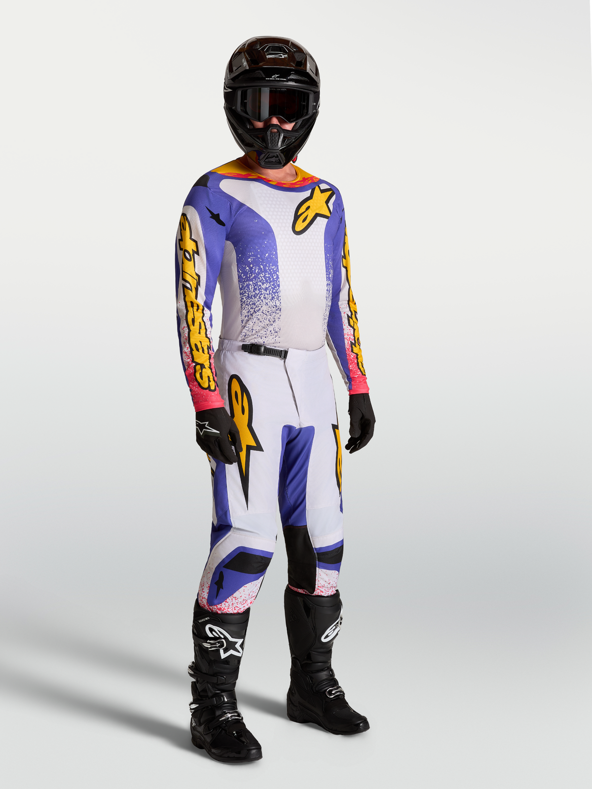 Alpinestars 2027 Fluid Drag Gear Set and Pants, Men's Motocross apparel in lilac, blue, and gold, shown on-model.