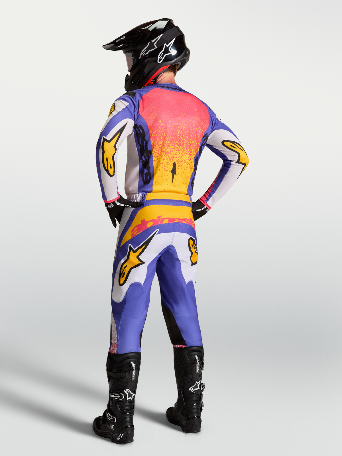 Alpinestars Fluid Drag Pants for men, blue and light lilac motocross gear with iris gold accents and a reinforced seat.